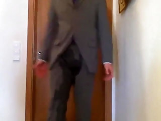 man in suit and tie peeing his pants